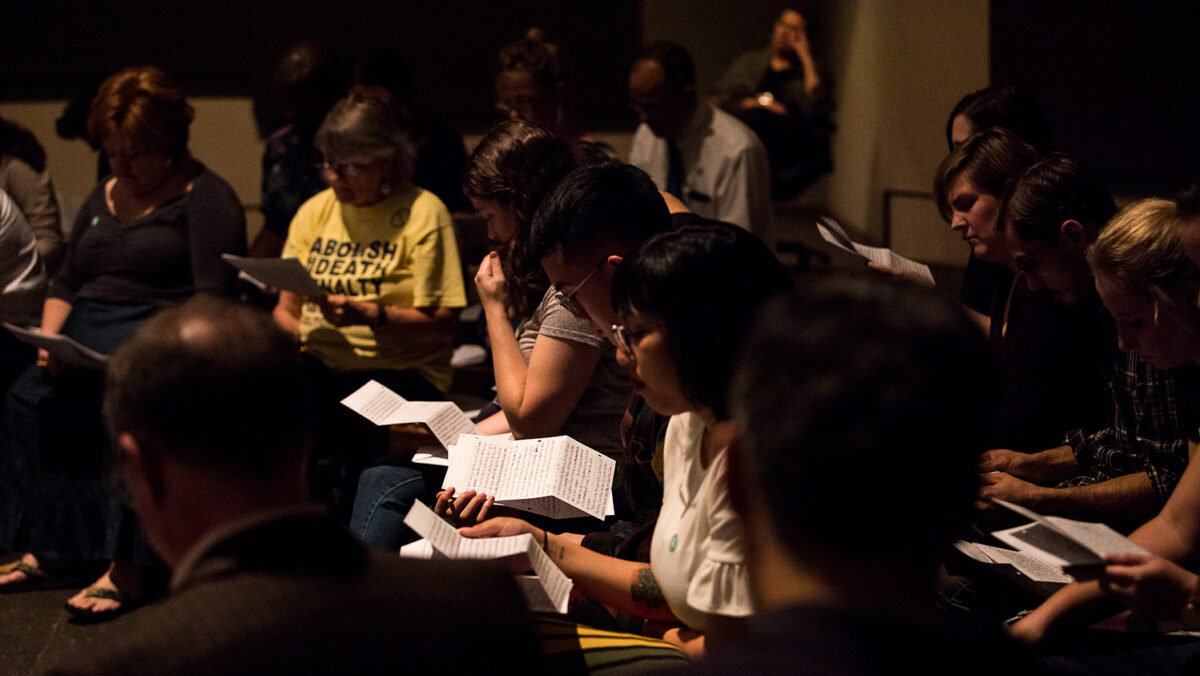 A woman surrouned by group reading a letter